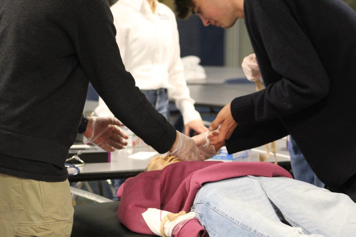 Students help the dummy for the medical station.