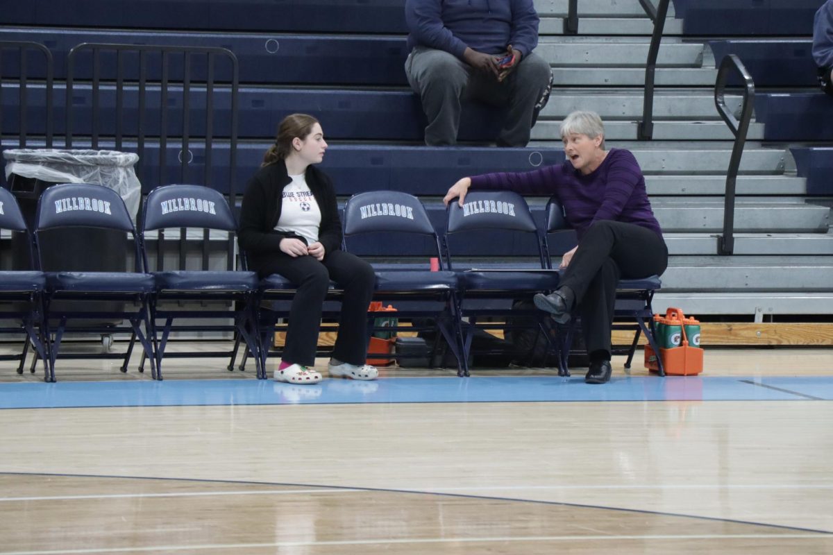 Varsity Coach Tracy Harding talks to team manager Grace Tyseinger during warmups.