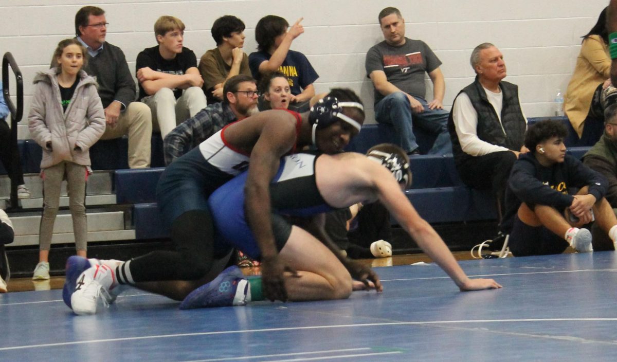 Junior Ariel Huseni tries to flip his opponent during the wrestling invitational.