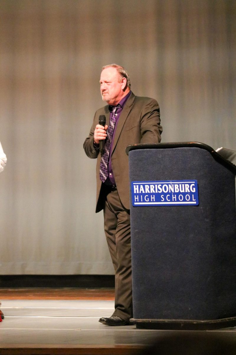Varsity football coach Kyle Gillenwater introduces an award he is going to give one of his athletes. 