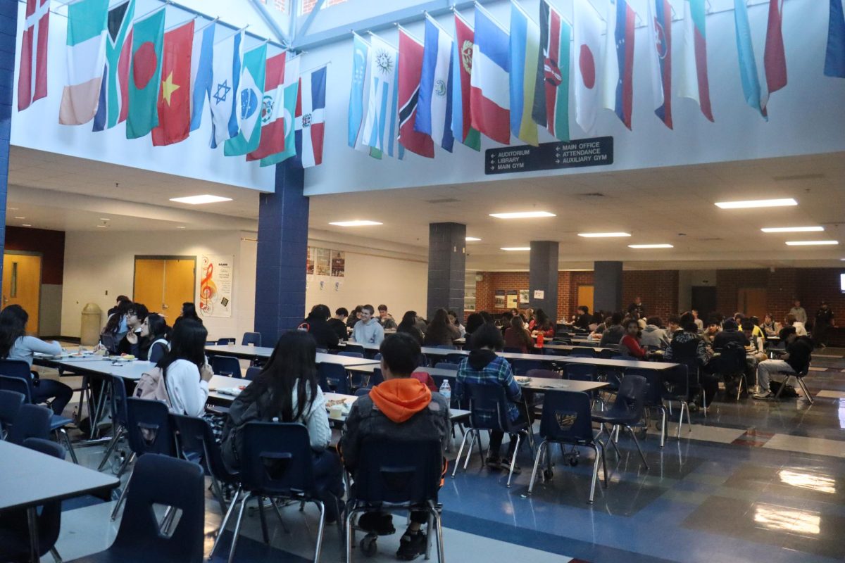 On the left side of the cafeteria near the auditorium, students are enjoying lunch and hanging out with friends.