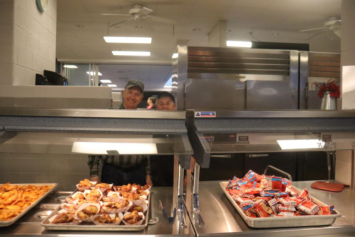 The lunch staff prepare food with joy.




