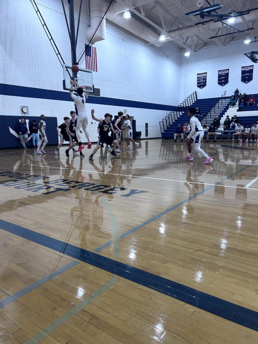 Yandel Robles attempts to make a basket, while being assisted by his team.