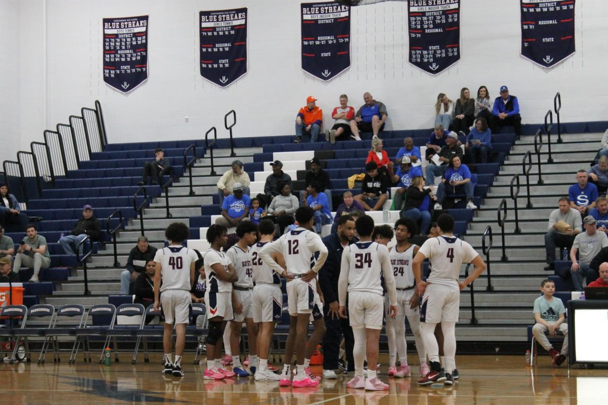 The boy's basketball team huddles up and have a discussion with coach Malcolm Thomas. 