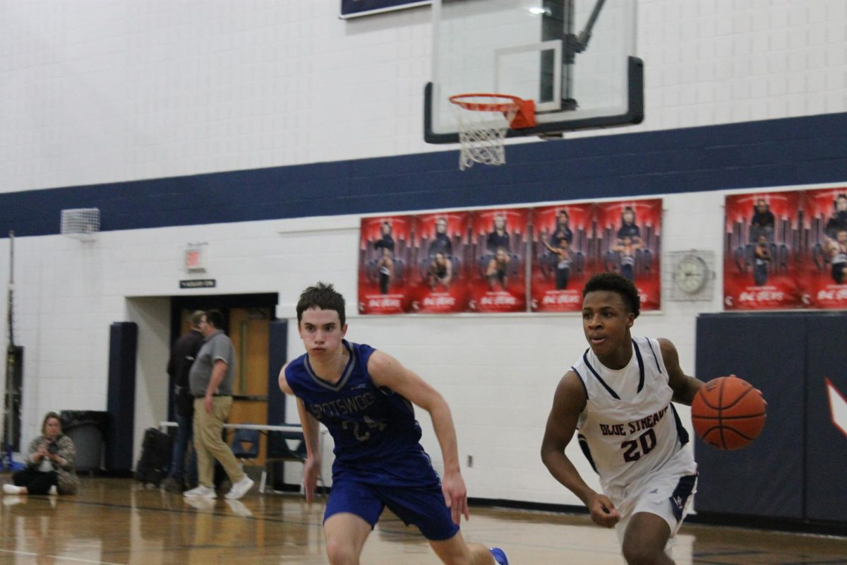 Freshman Keyon Benton runs down the court while dribbling the ball. 