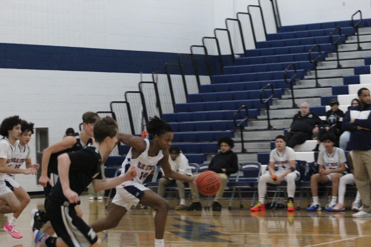 Sophomore Malek Jones dribbles the ball down the court. 