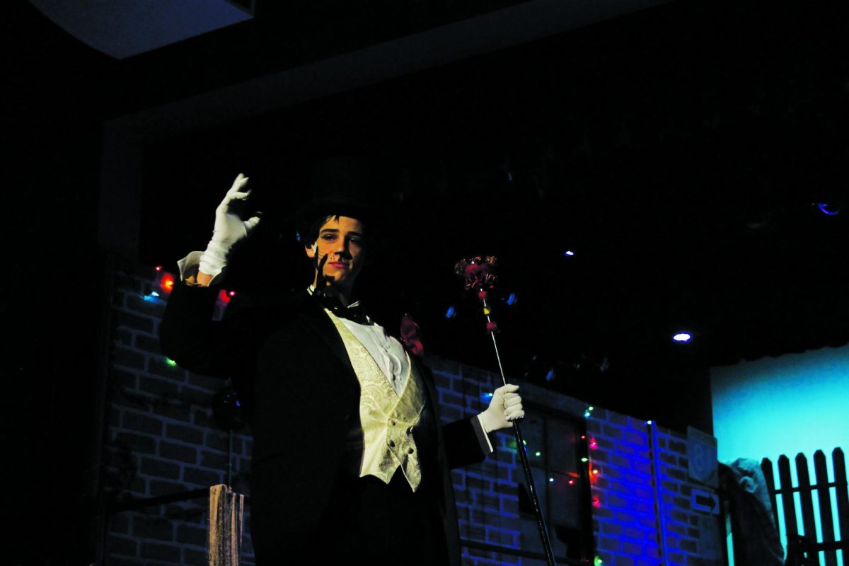 Bustopher Jones, played by Tristian Nussbaum, waves his hand towards the audience during his performanc. 