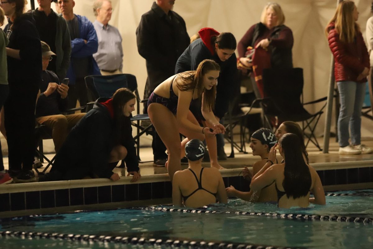 Girls swim team chats about race after cooldown lap.