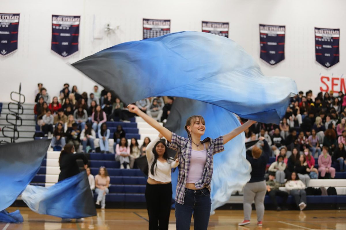Color guard waves flags during the winter pep rally. 