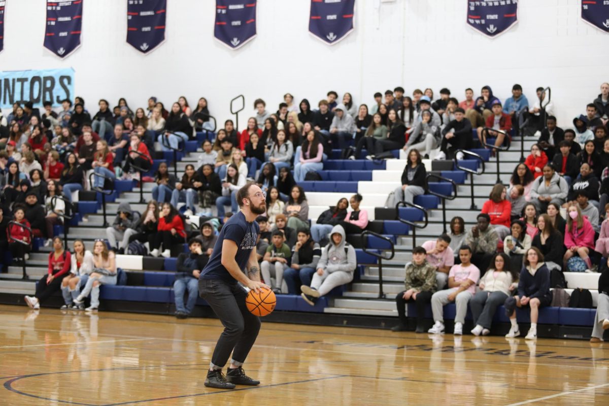 Teacher Erich Sneller prepares to shoot a free throw during a competition game at the winter pep rally. 