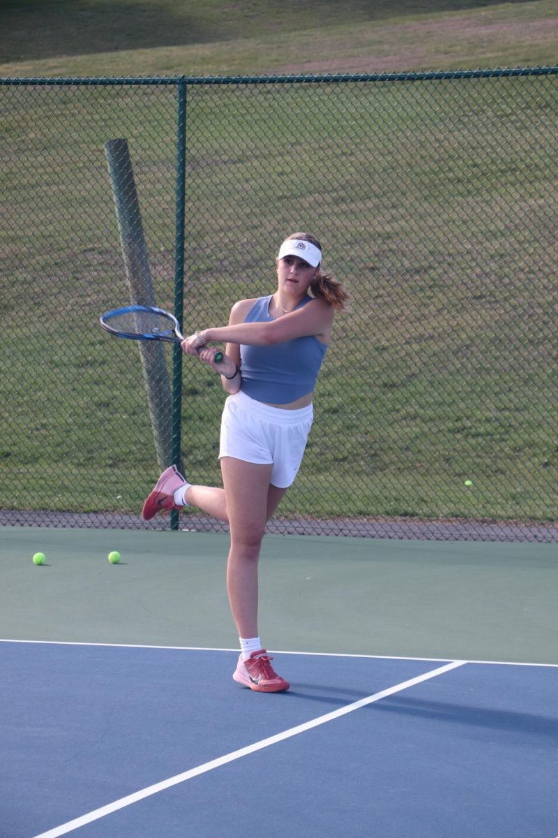 Junior Evelyn Lewis follows through during a double match during practice. 