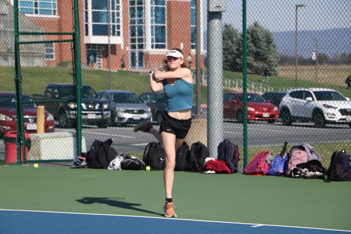 Senior Clare Kirwan follows through after hitting the ball during a doubles game at practice. 