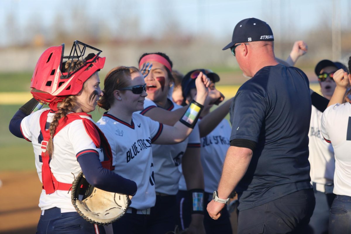 Head Coach Derek Smiley chants with the team after the first inning.