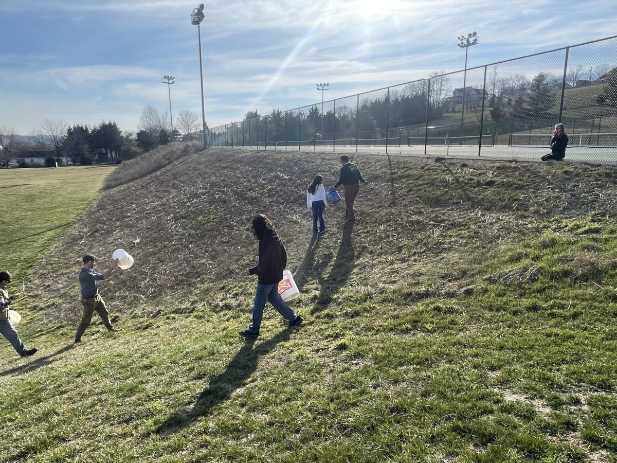 Earth Club members throwing the last seeds that they have in their buckets.