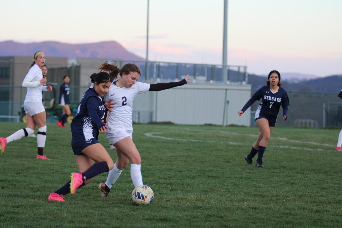 Senior Angie Delcid Lopez presses her opponent in attempt to win the ball.