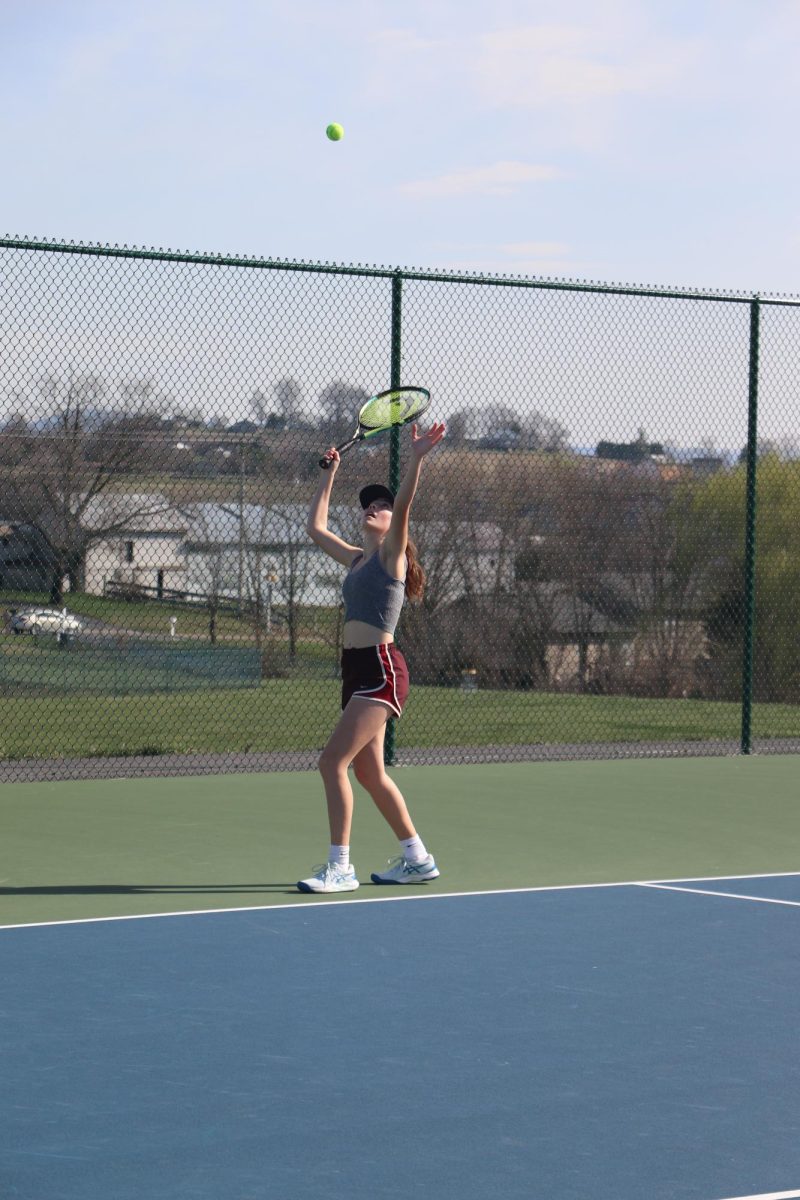 Junior Sequoia Hall serves the ball for a doubles match during practice. 