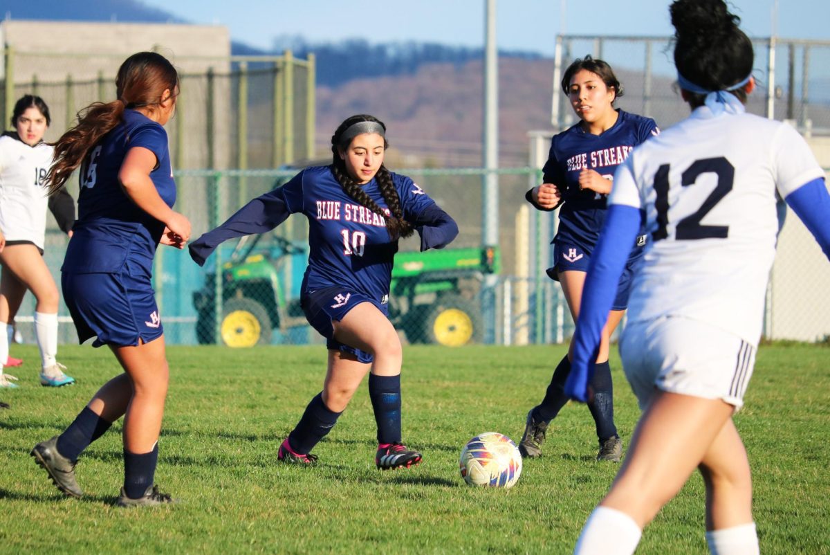 Sophomore Sara Hussein dribbles past defenders.