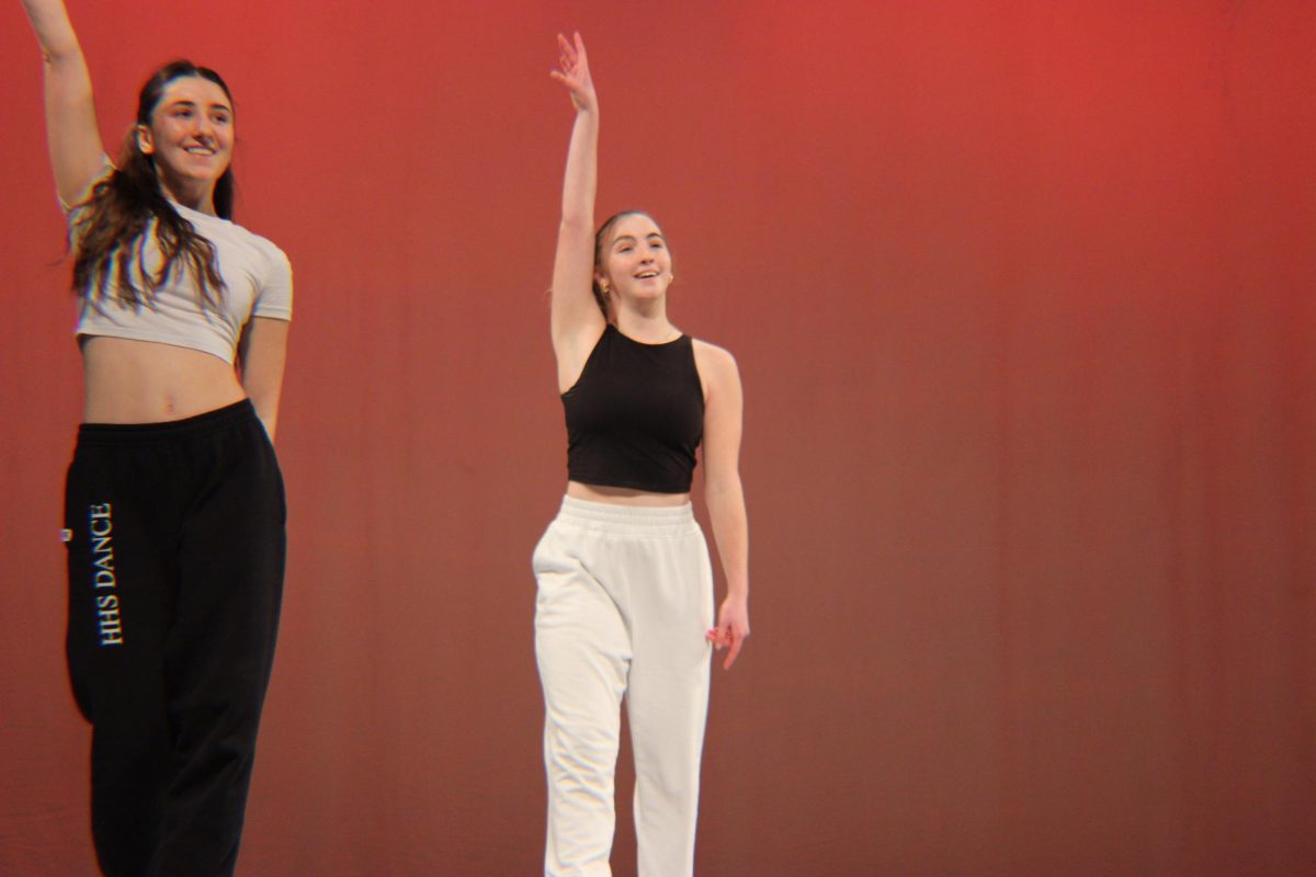 Junior Lydia King and sophomore Annie Snow perform in a group dance piece.