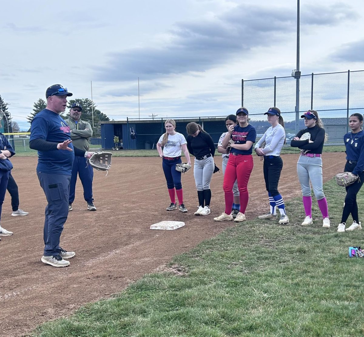 Coach Derek Smiley explains plays to JV players after errors in their past game.