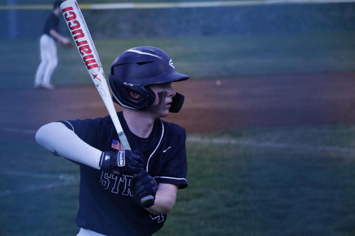 Junior Cayden Lucas practices hitting before getting on field.