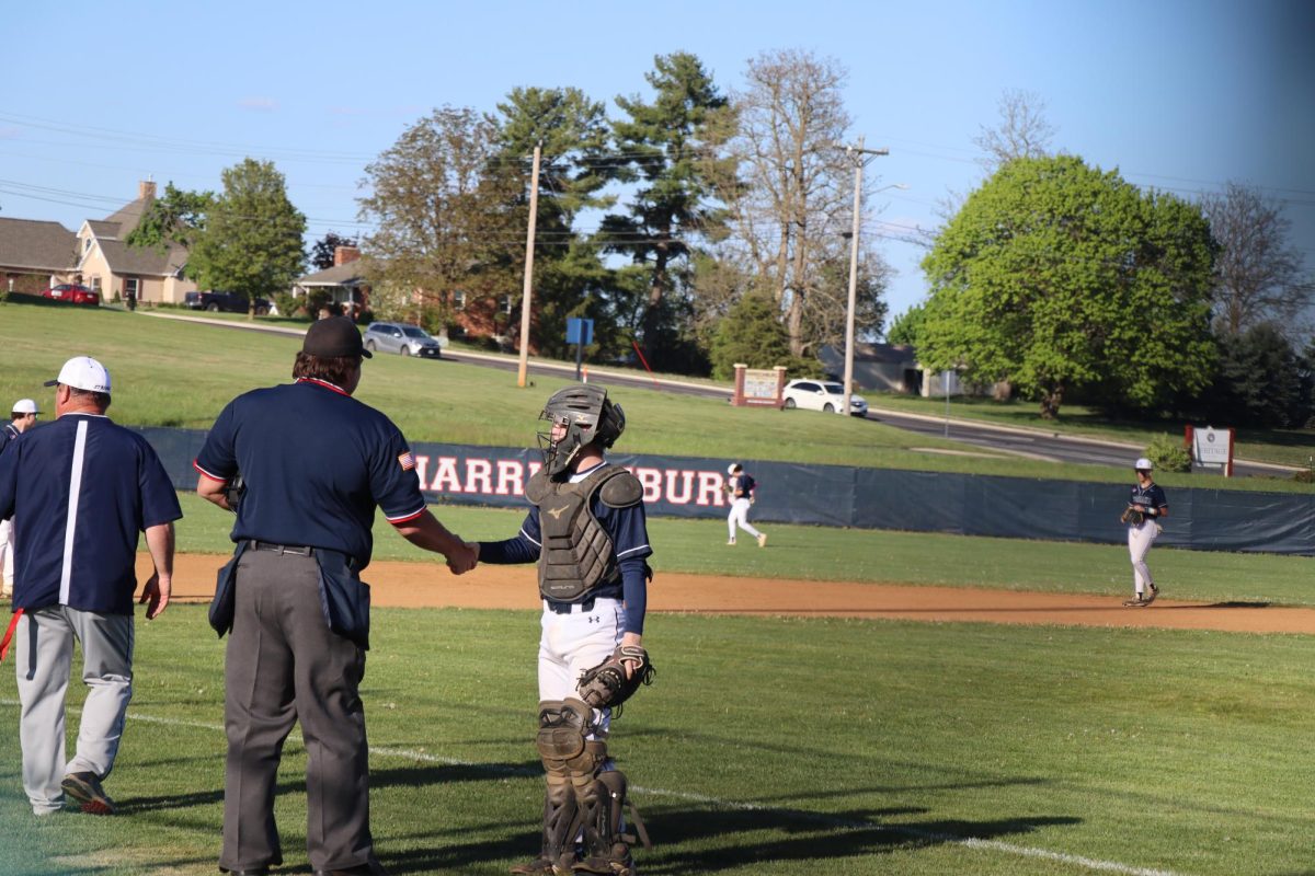 Varsity baseball player receiving a handshake.