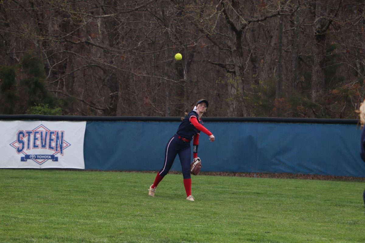 Senior Camryn Johnson warms up before the second inning to play in the outfield at  Spotswood High School. 