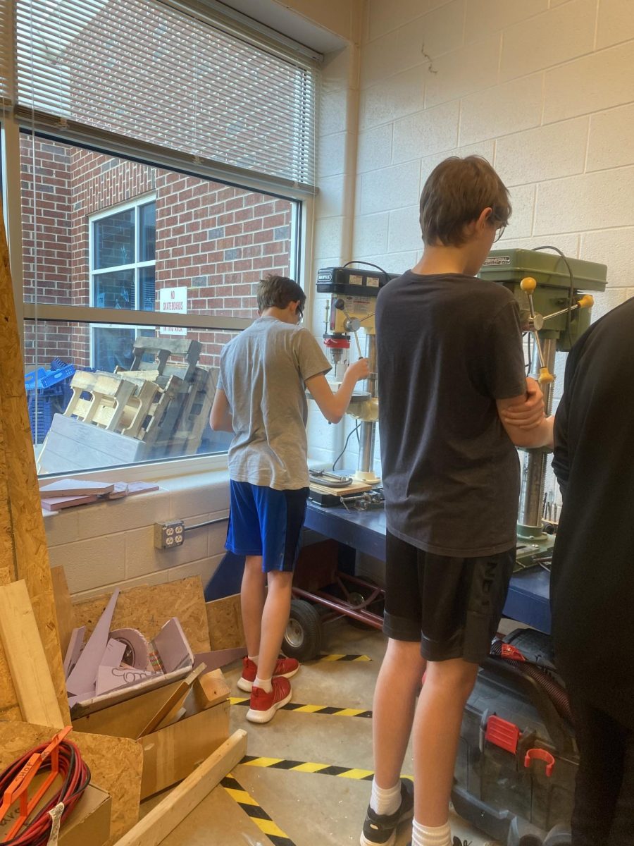 Freshman Luke Snider observes machine before cutting into wood.