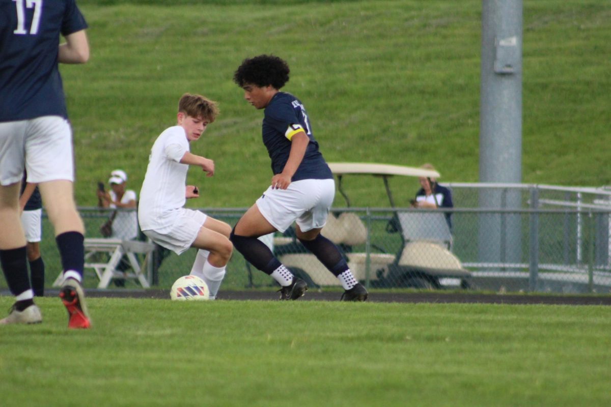 Sophomore Kaiden Velasquez chopping the ball back against a defender.