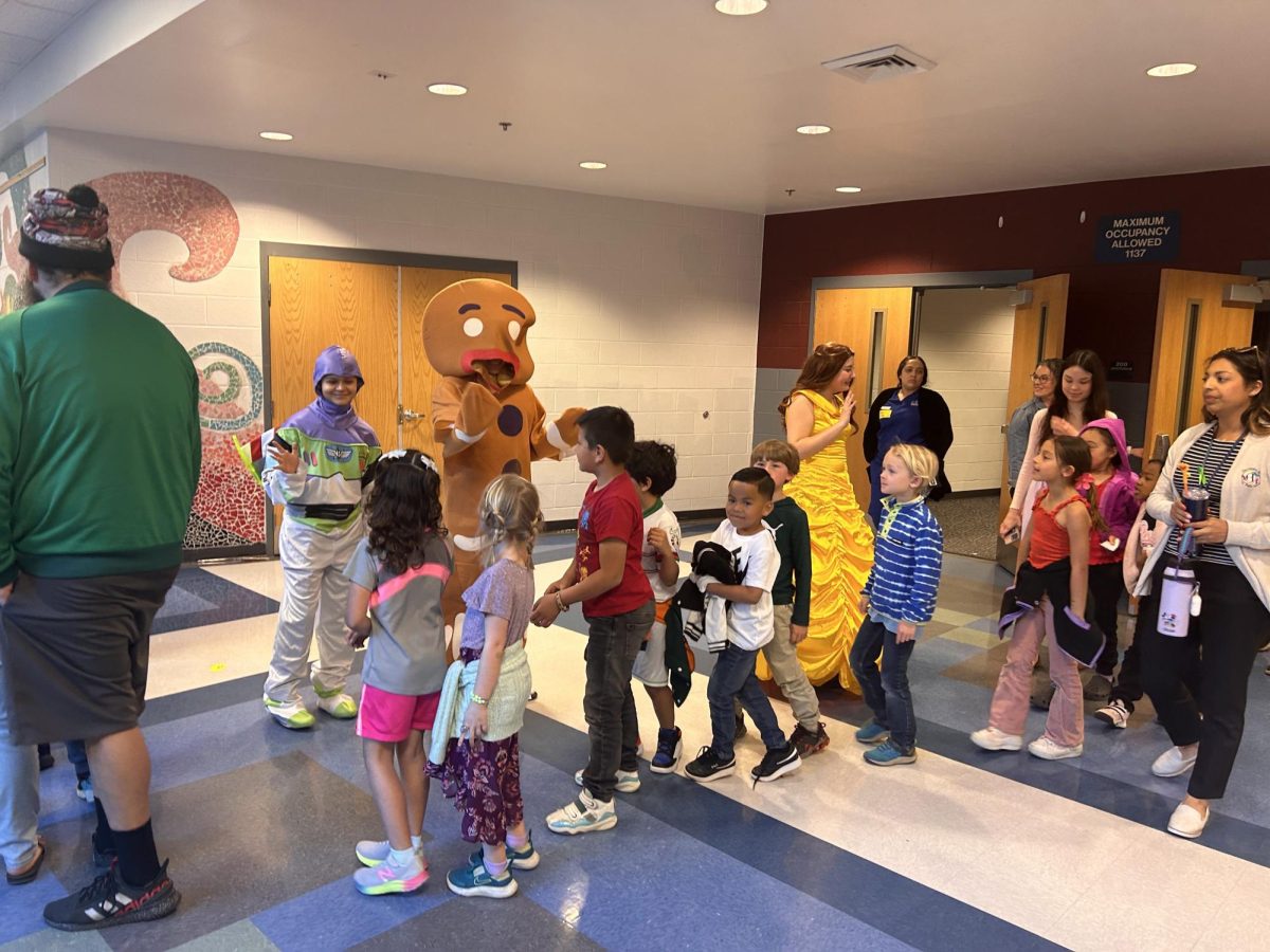 Students greet the characters from Tiny Tots.
