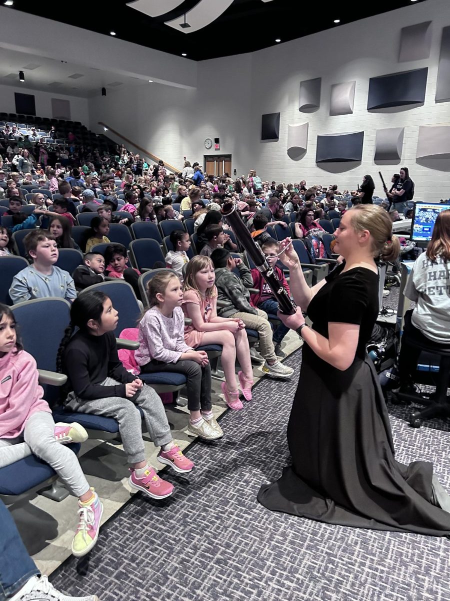 Johanna Mayfield demonstrates how to use her instrument to students watching.