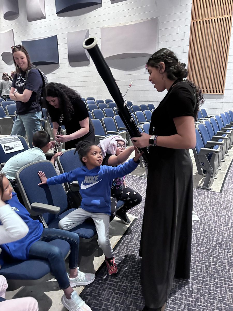 Sophomore Jireh Perez shows and demonstrates how to use her instrument to the children. 