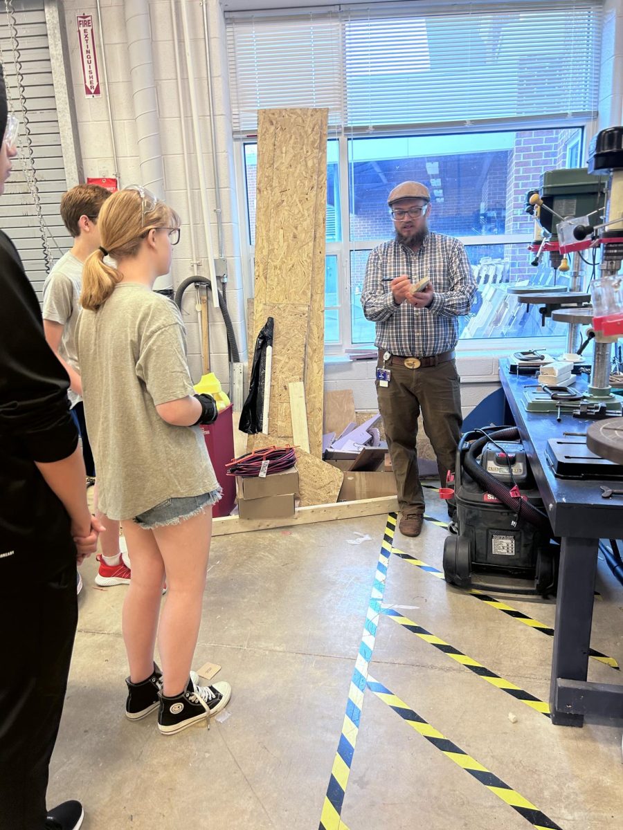 Mr. Shantz explains the instructions to drill a hole in the wood.