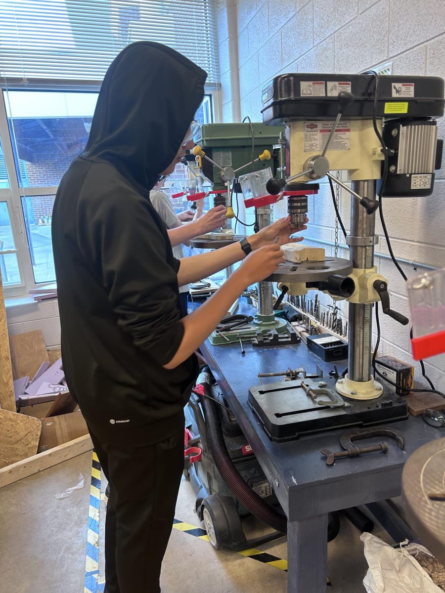 Freshman Briant Sosa Cabara works on drilling a hole in a piece of wood.