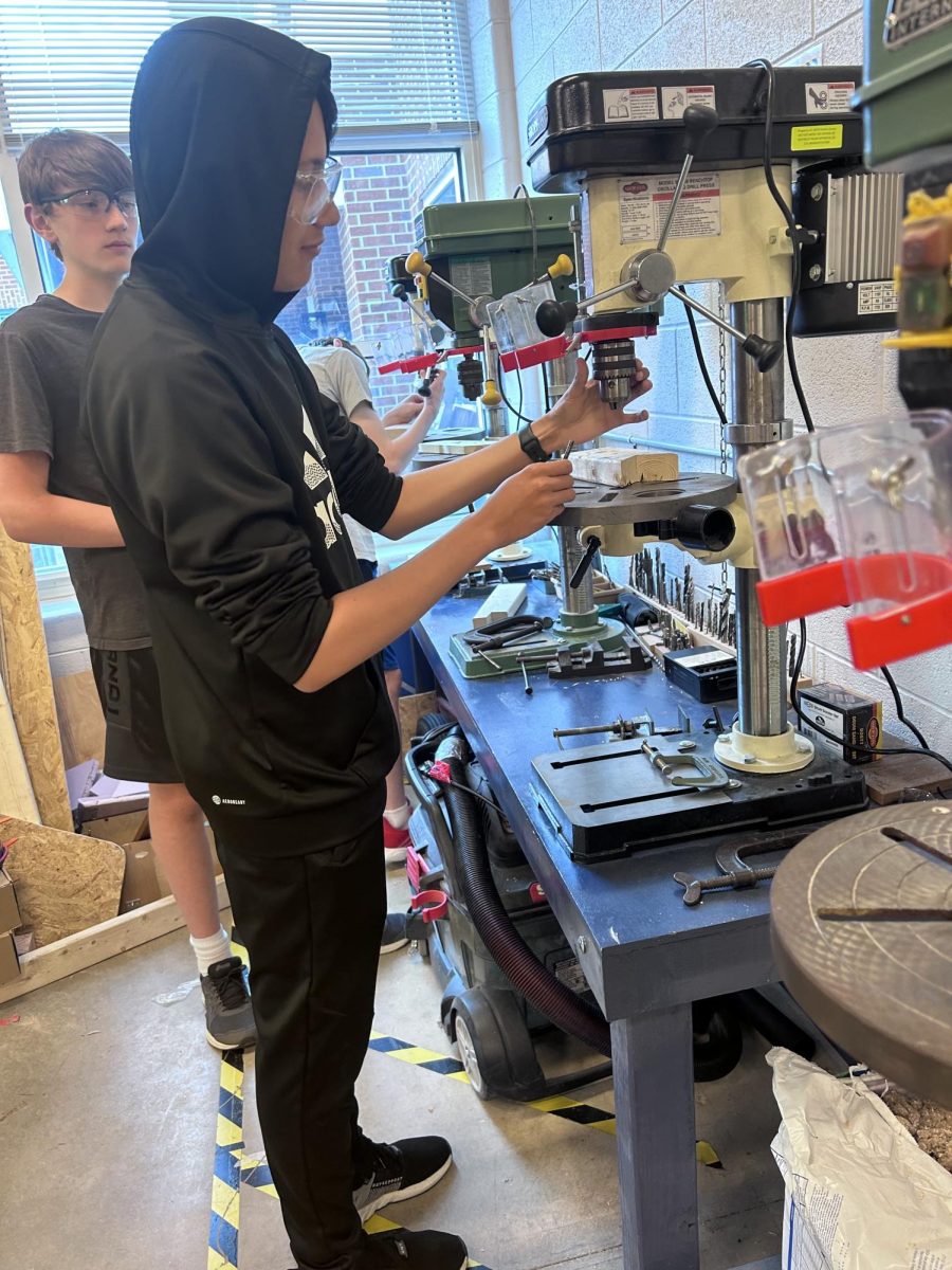 Freshman Briant Sosa Cabara works on adding the drill to make a hole in the wood.