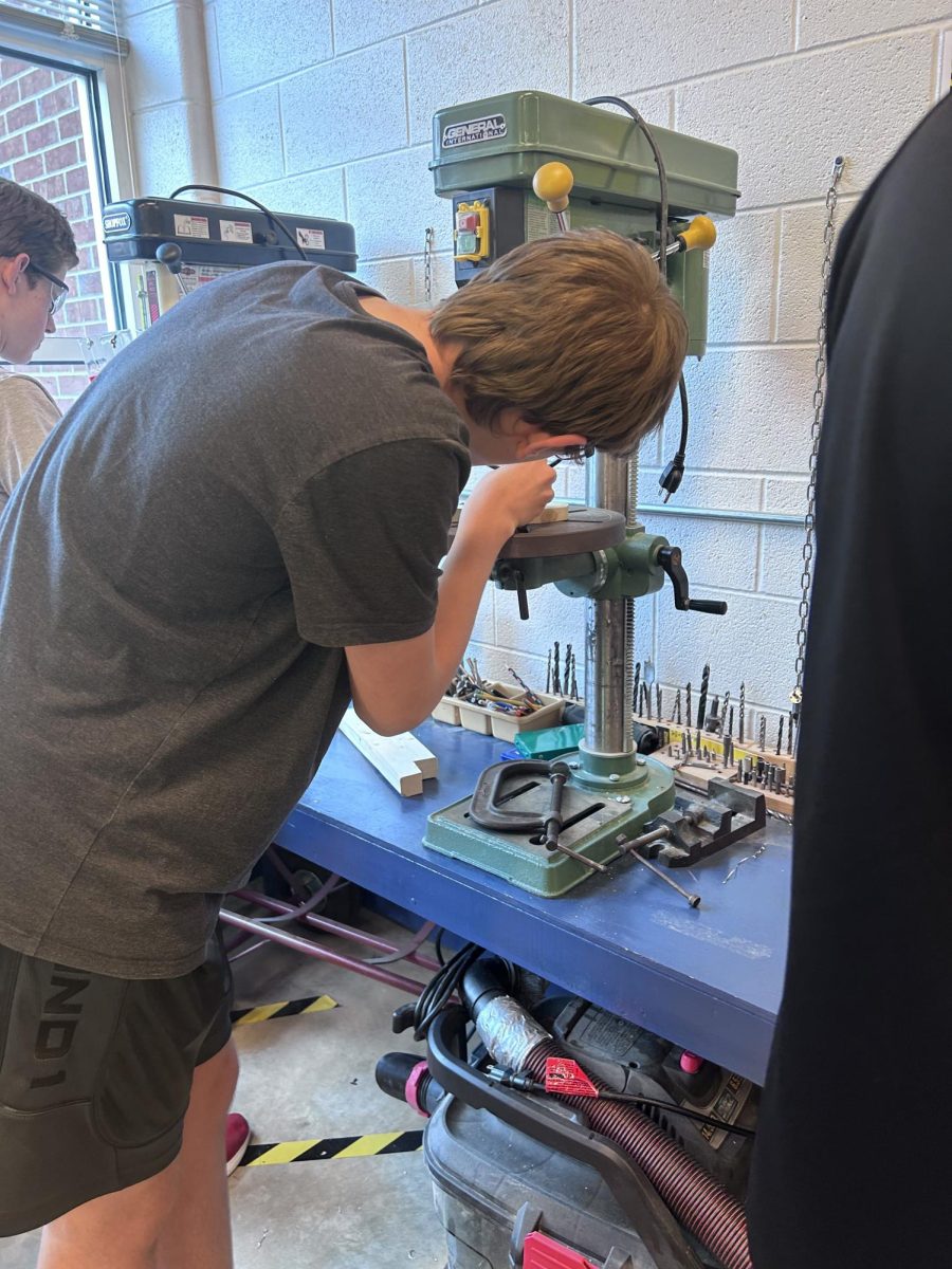 Freshman Elias Mercer works on adjusting the machinery.