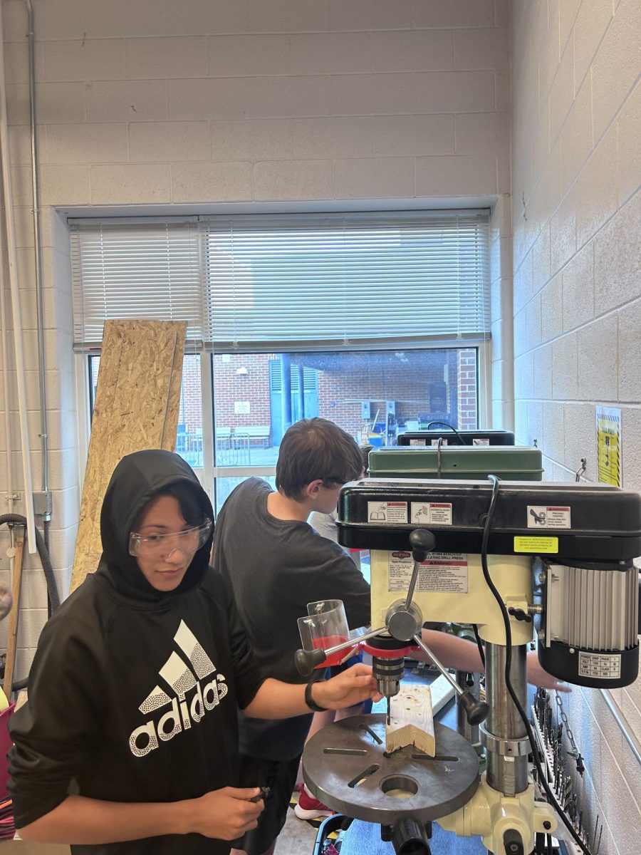 Freshman STEM Innovations students work on adjusting machines to drill.