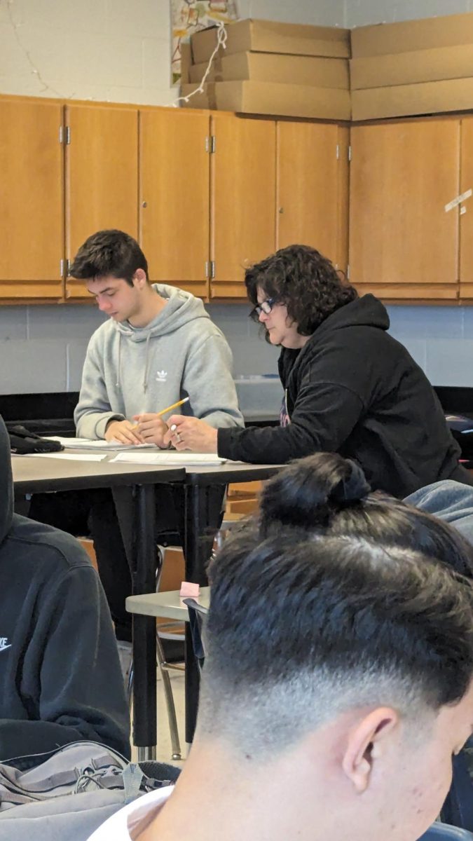 Assistant helps group of students.