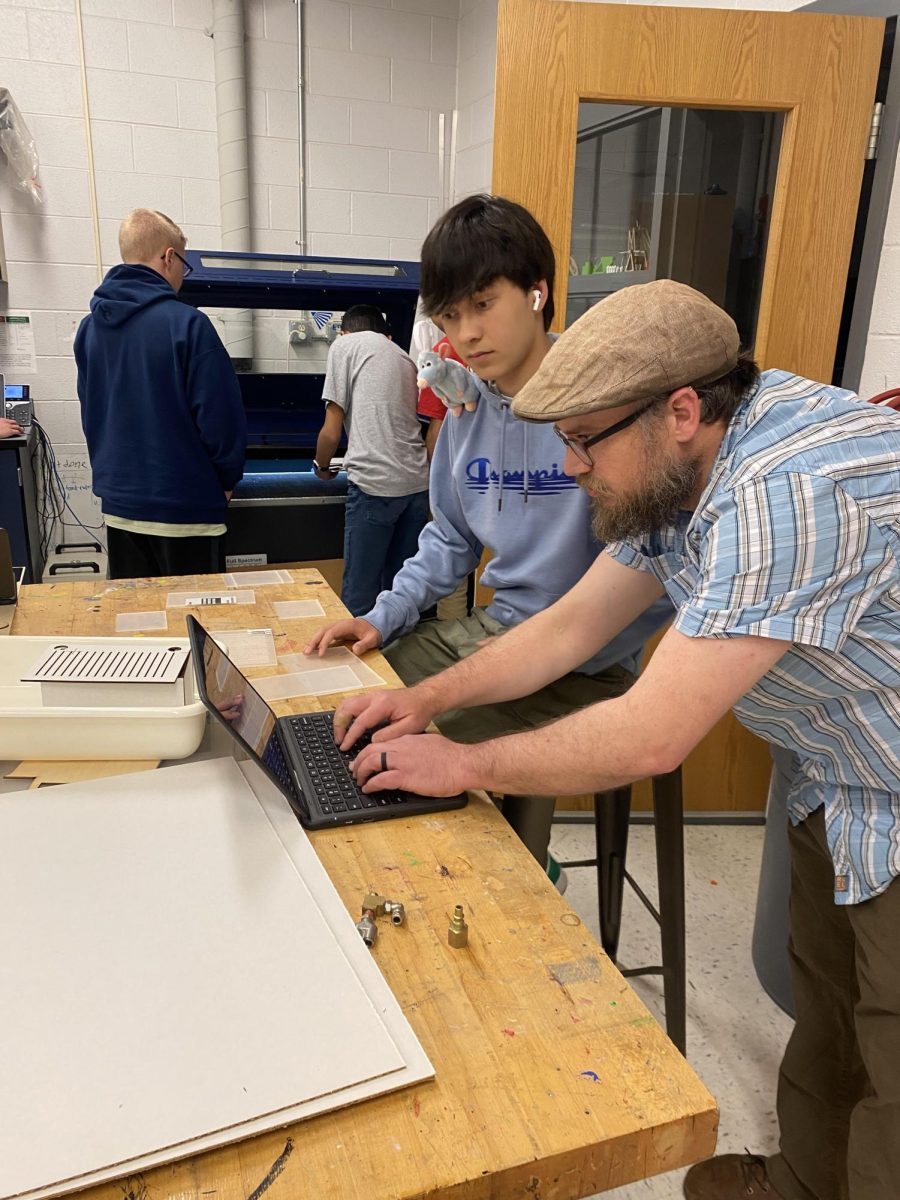 Innovation teacher Mr. Shantz helps out a student