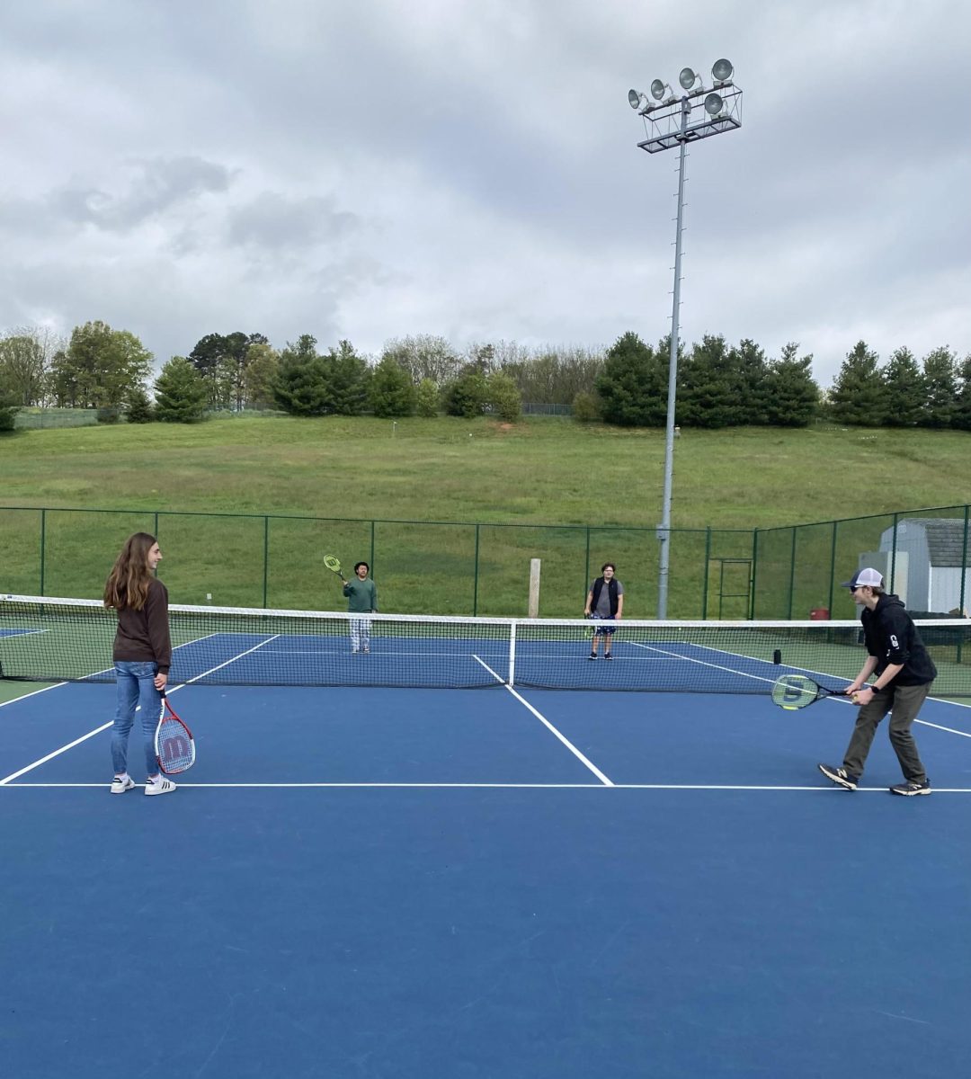 Bethany Rush plays tennis with fellow classmates
