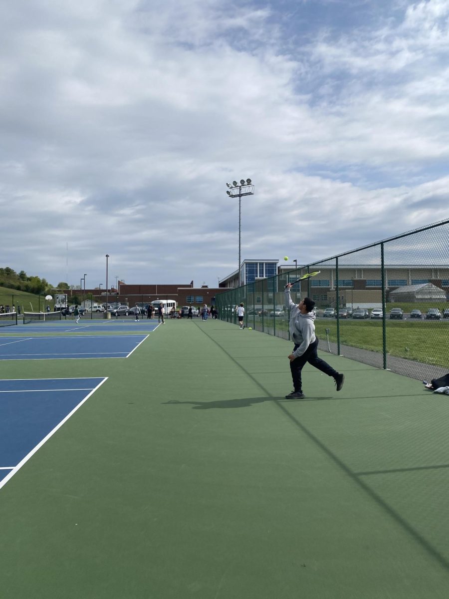 Student gets ready to serve the tennis ball to classmate