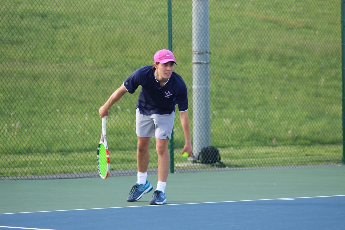 Senior Julien Steins serves for his singles match against East Rock. 