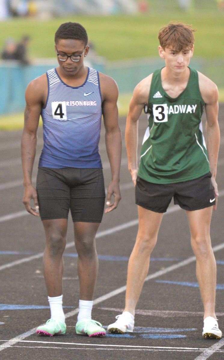 Junior Ariel Huseni stands next to a Broadway runner at the starting line.  