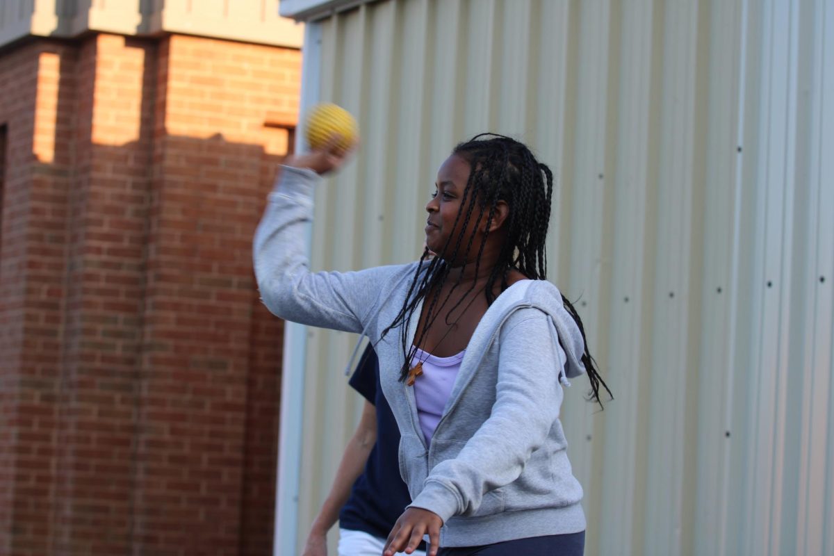 Student throws a ball at dunk tank in attempt to dunk Dean of Students Don Burgess.