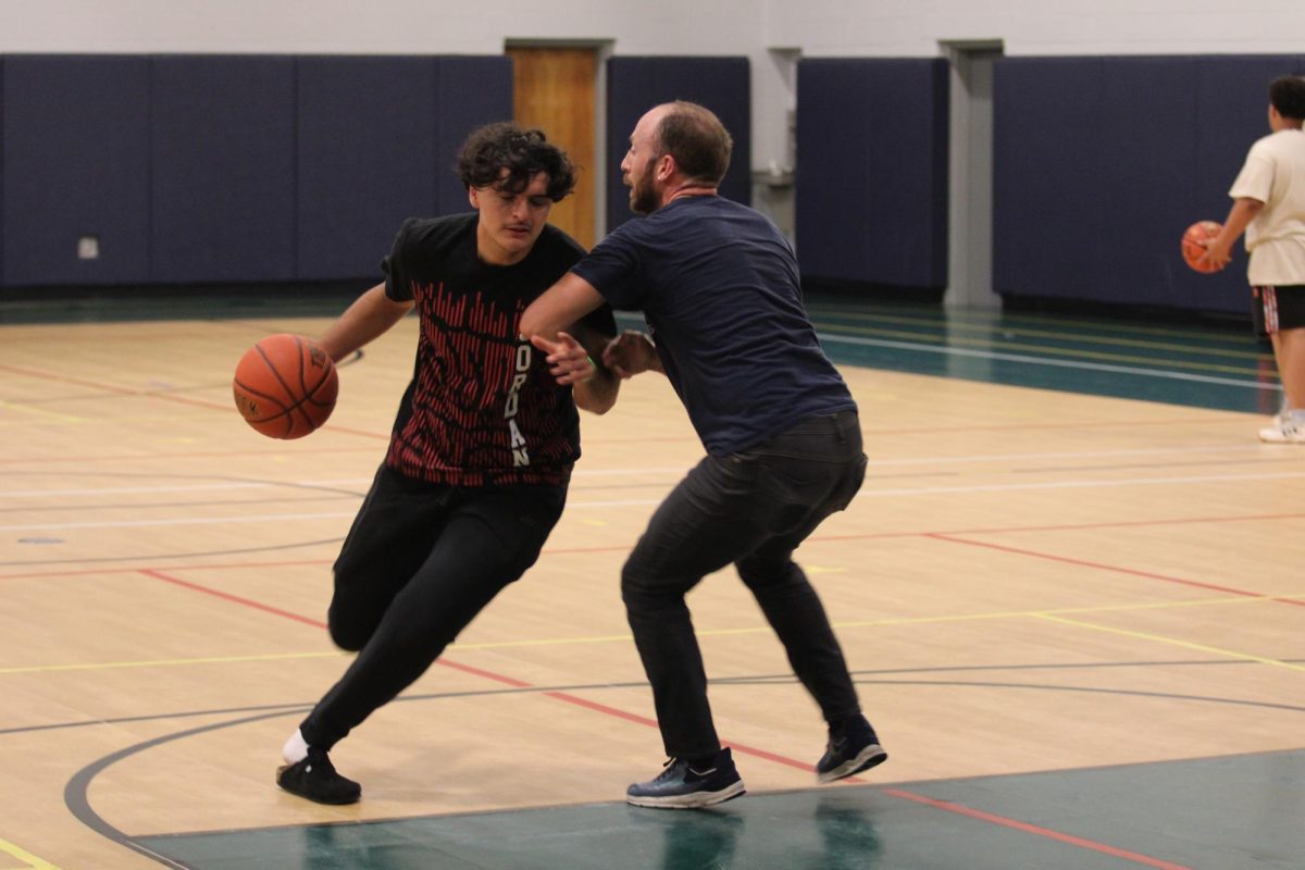 Student plays basketball against science teacher Erich Sneller. 