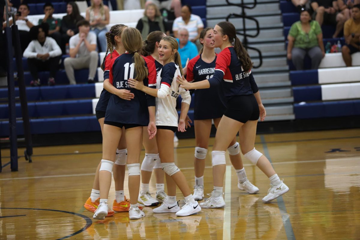 The varsity volleyball team celebrates after winning a point. 