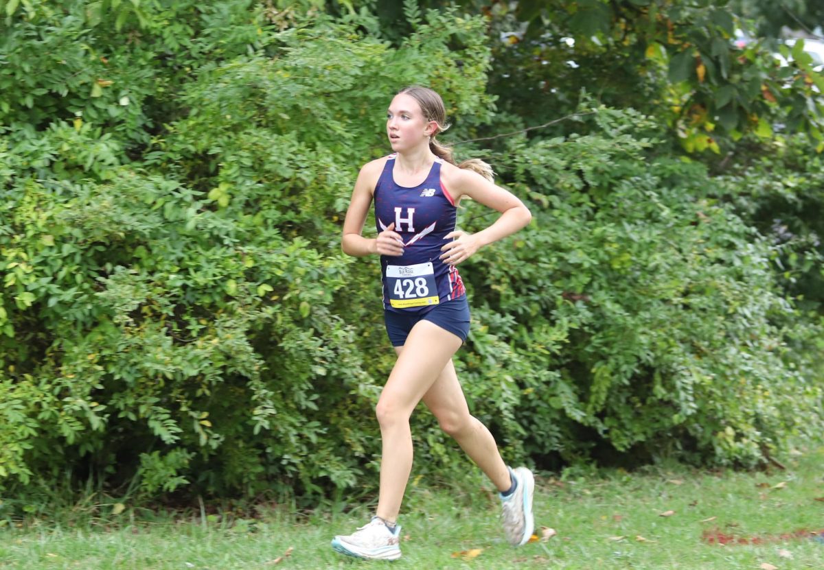 Junior Abby Gibson jogs around a turn in an attempt to catch up to the leader at Thomas Harrison Middle School.