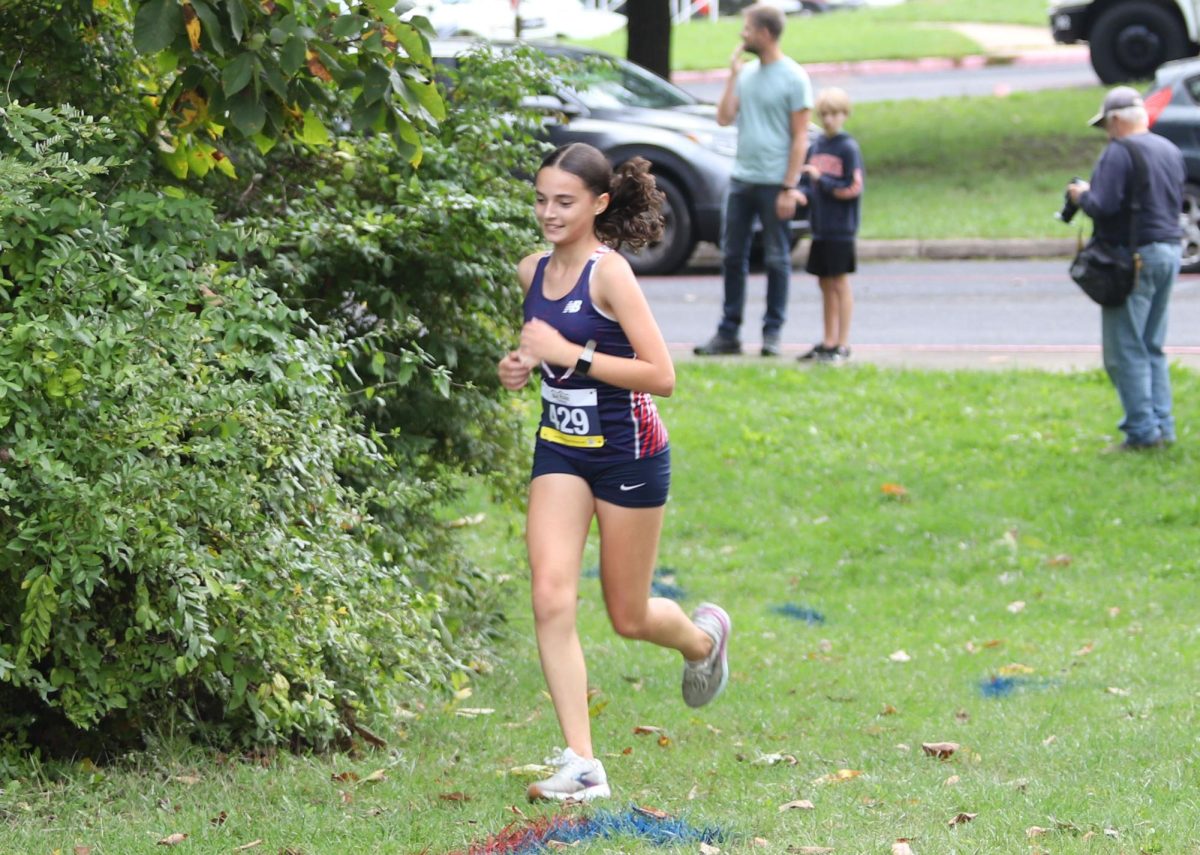 Freshman Eliza Godshall races up a hill on her last lap of the home cross country race.