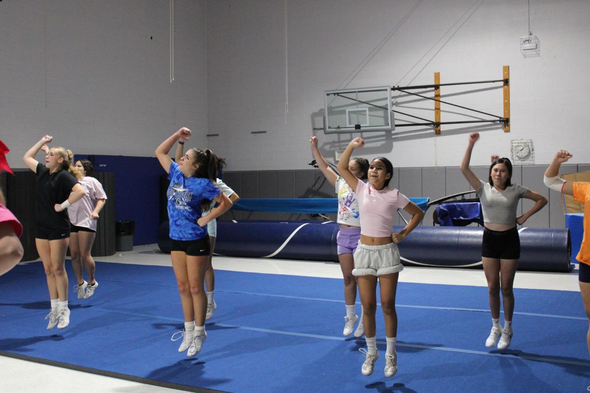 Jv sideline cheerleaders cheering during practice to participate with Varsity cheerleaders.