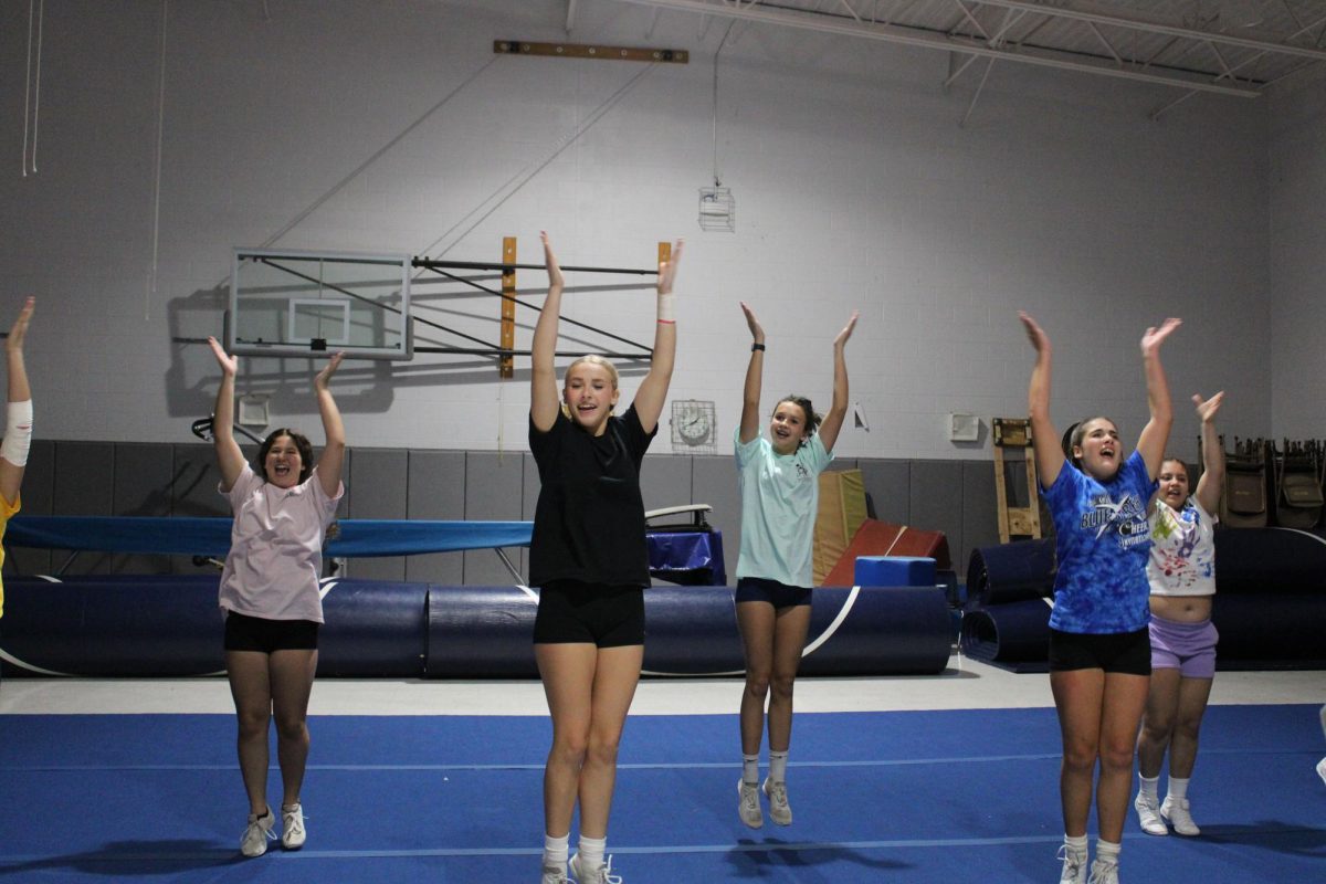 Jv cheerleaders cheering to prepare for football game.