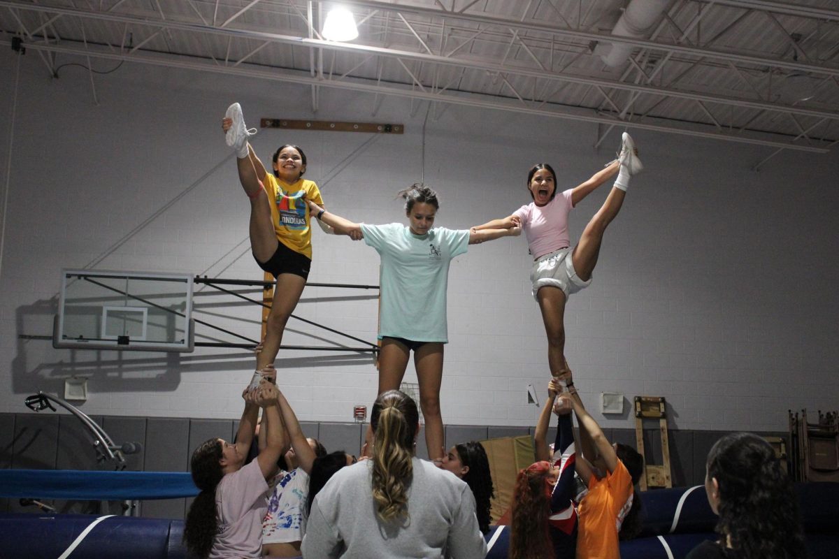 Freshmans Gretel and Mirna flying heel stretch libs as Freshman Danica braces them.
